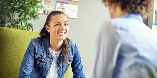 zwei Frauen sitzen sich gegenüber und unterhalten sich