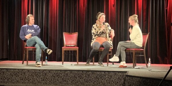 Junge Frau sitzt mit zwei Moderatorinnen auf der Bühne