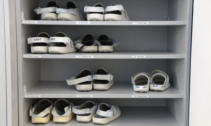 Schuhregal mit weißen Arbeitsschuhen im Ferdinand-Braun-Institut, Leibniz-Institut für Höchstfrequenztechnik, in Berlin-Adlershof
