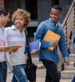 Eine Gruppe internationaler Studierende unterhalten sich und lachen, während sie zum Unterricht gehen.
