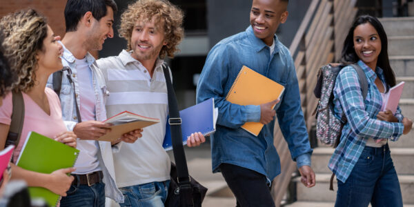 Eine Gruppe internationaler Studierende unterhalten sich und lachen, während sie zum Unterricht gehen.