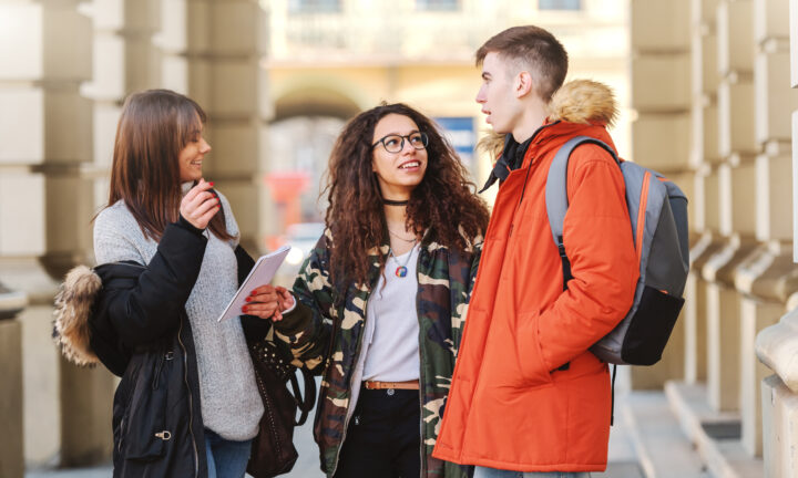 Zwei junge Frauen und ein junger Mann unterhalten sich