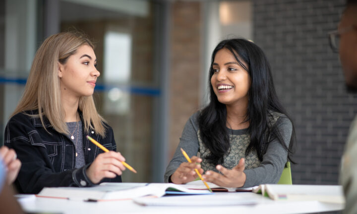 Zwei weibliche Studierende arbeiten zusammen an einer Aufgabe.