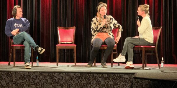 Eine junge Studienabbrecherin berichtet auf der Bühne von ihrem Werdegang bei der Fuckup:Studienabbruch im November 2021 in Hannover. Die Moderatorin hört ihr zu. Links sitzt der Moderator.