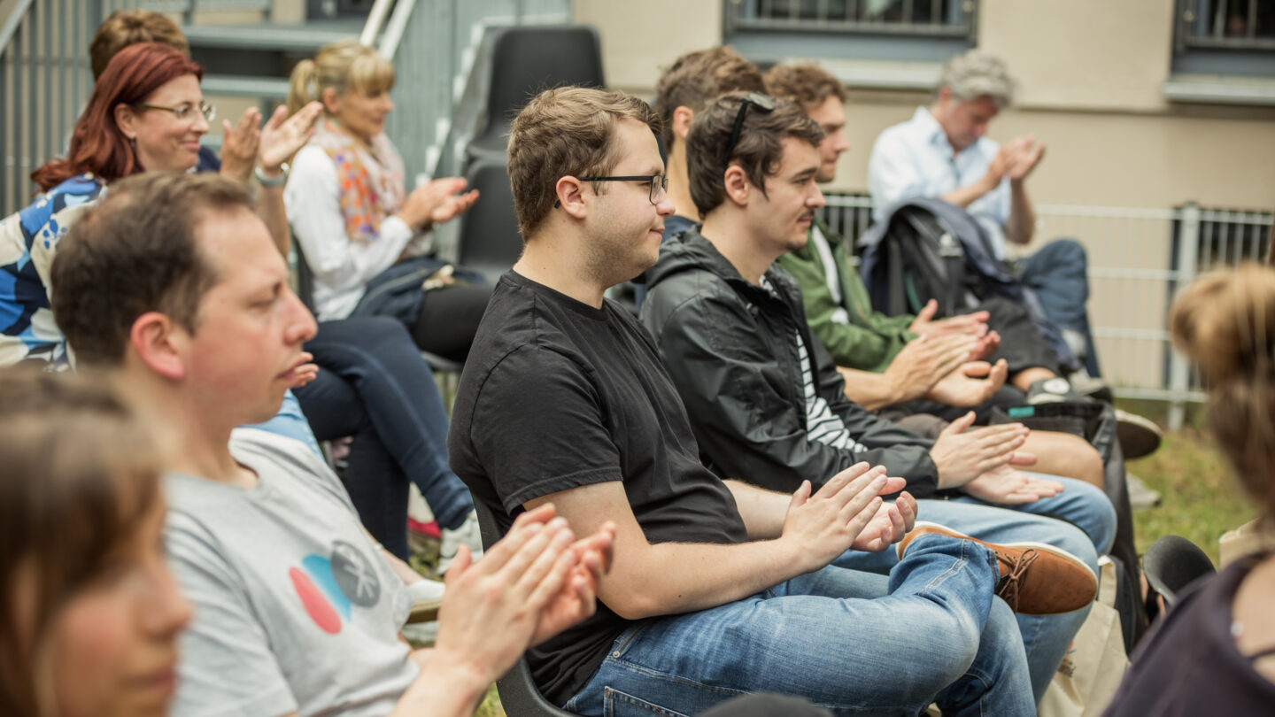 Junge Menschen im Publikum klatschen