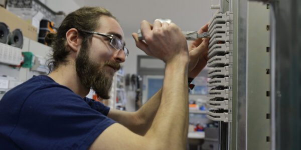 Ein junger Mann an einem Schaltkasten