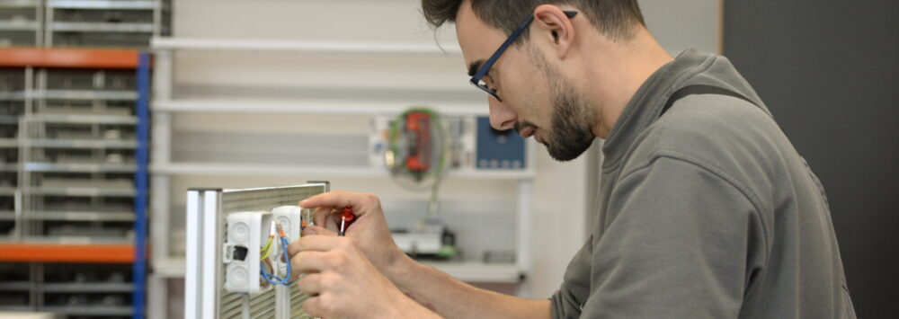 Ein junger Mann an einem elektrischen Schaltübungsplatz