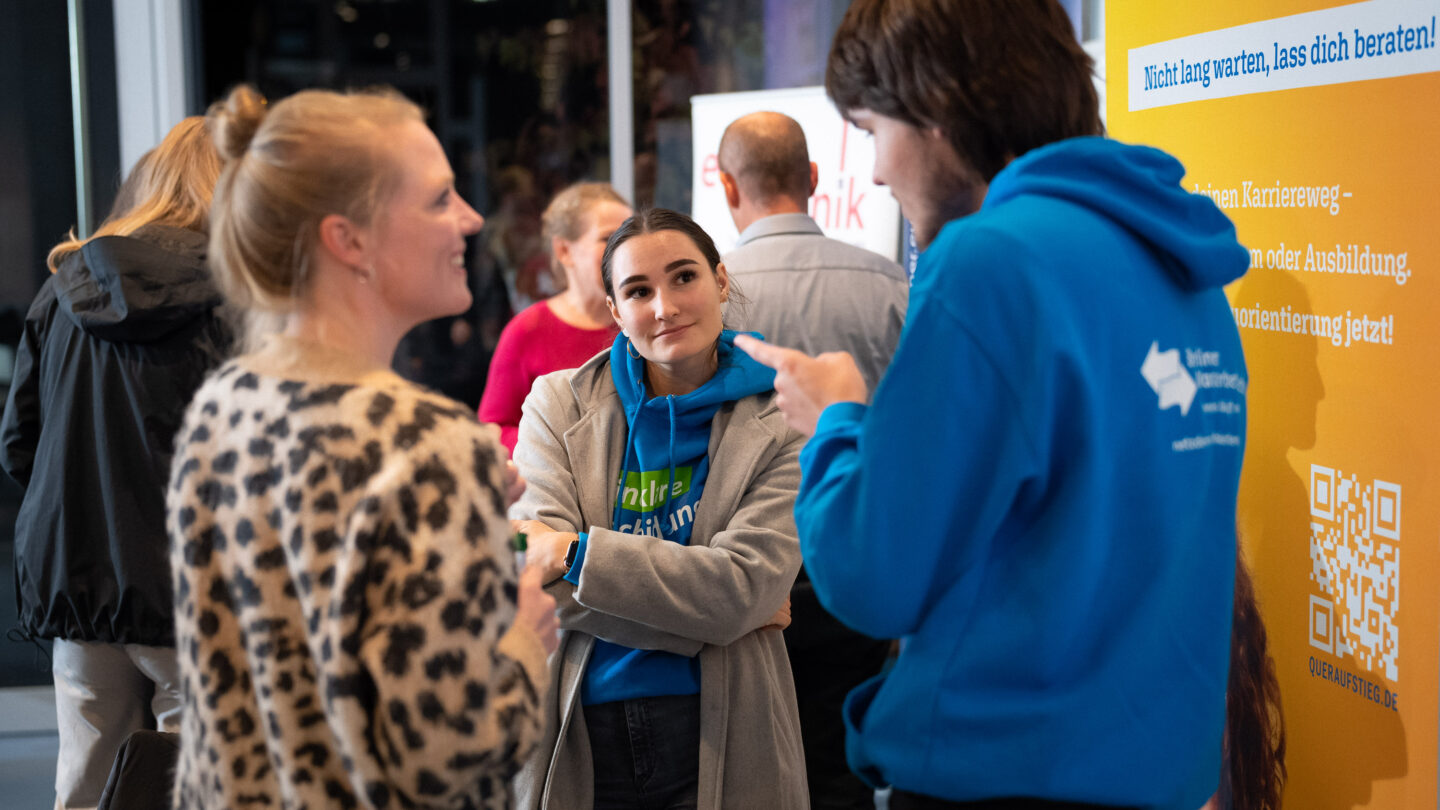 Zwei Frauen und ein junger Mann unterhalten sich