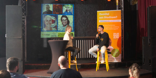 Die Moderatorin sitzt mit ihrem Gast auf der Bühne.