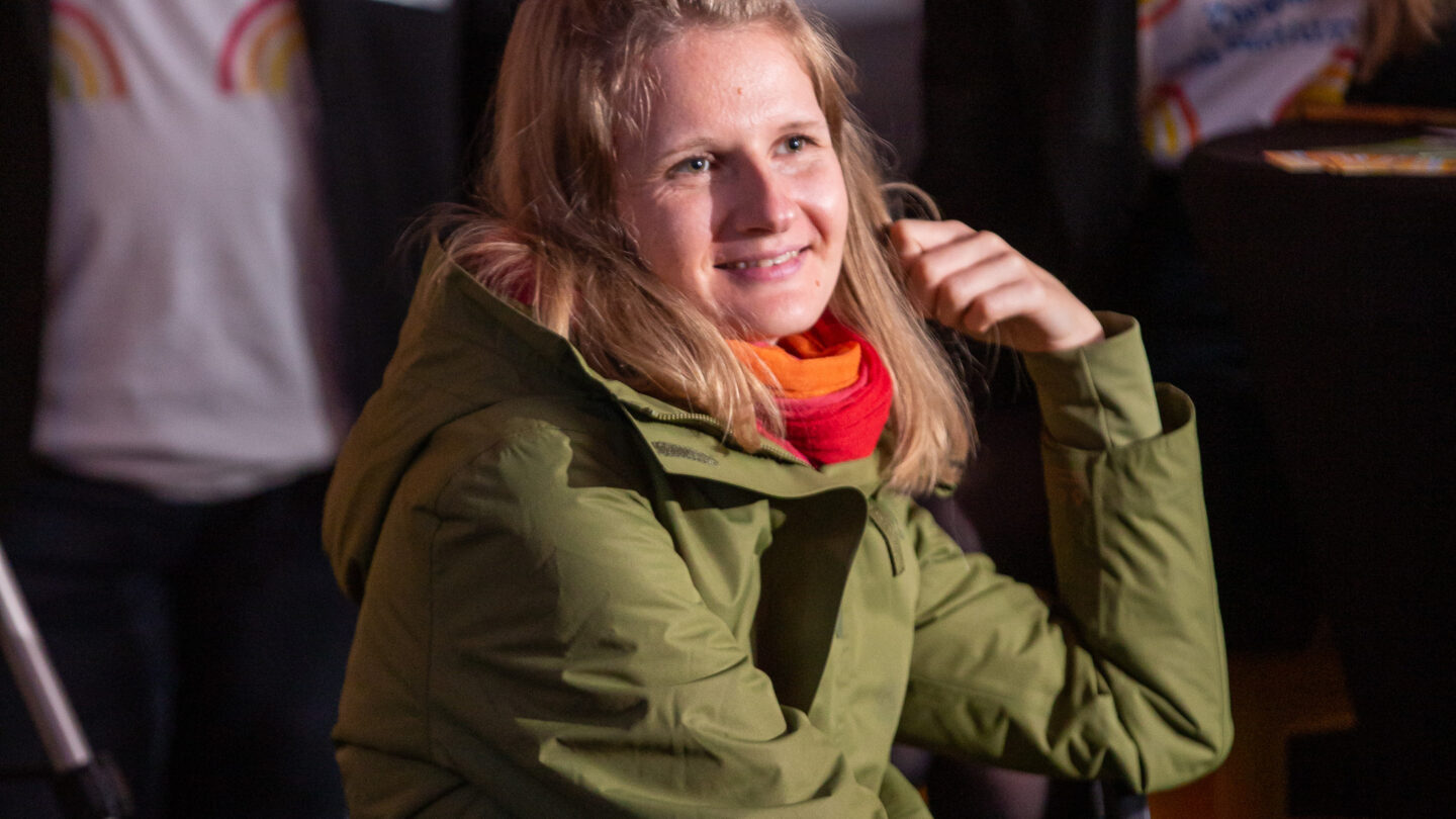 Eine junge Frau sitzt und lacht.