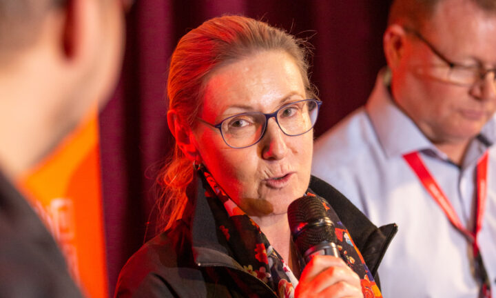 Eine Frau mittleren Alters spricht in das Mikrofon