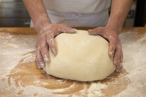 Zwei Hände auf einem Brotteig
