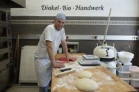 Ein Bäckerazubi am Arbeitstisch.