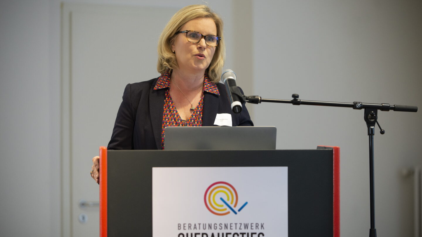 Eine Frau steht am Rednerpult und hält eine Rede