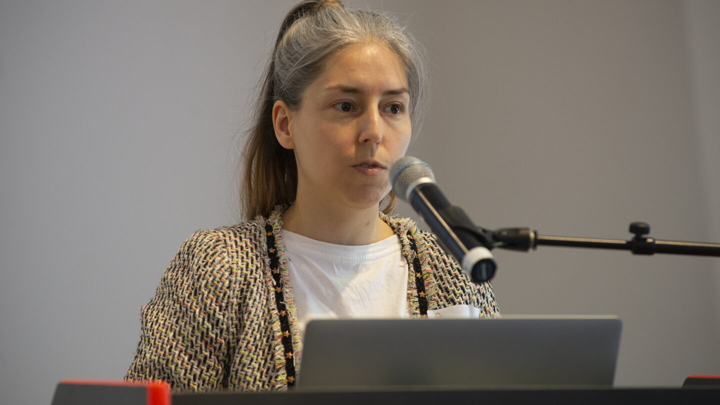 Eine Frau steht am Rednerpult und hält eine Rede