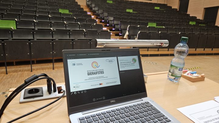Laptop mit Präsentation des Beratungsnetzwerkes Queraufstieg im Hörsaal
